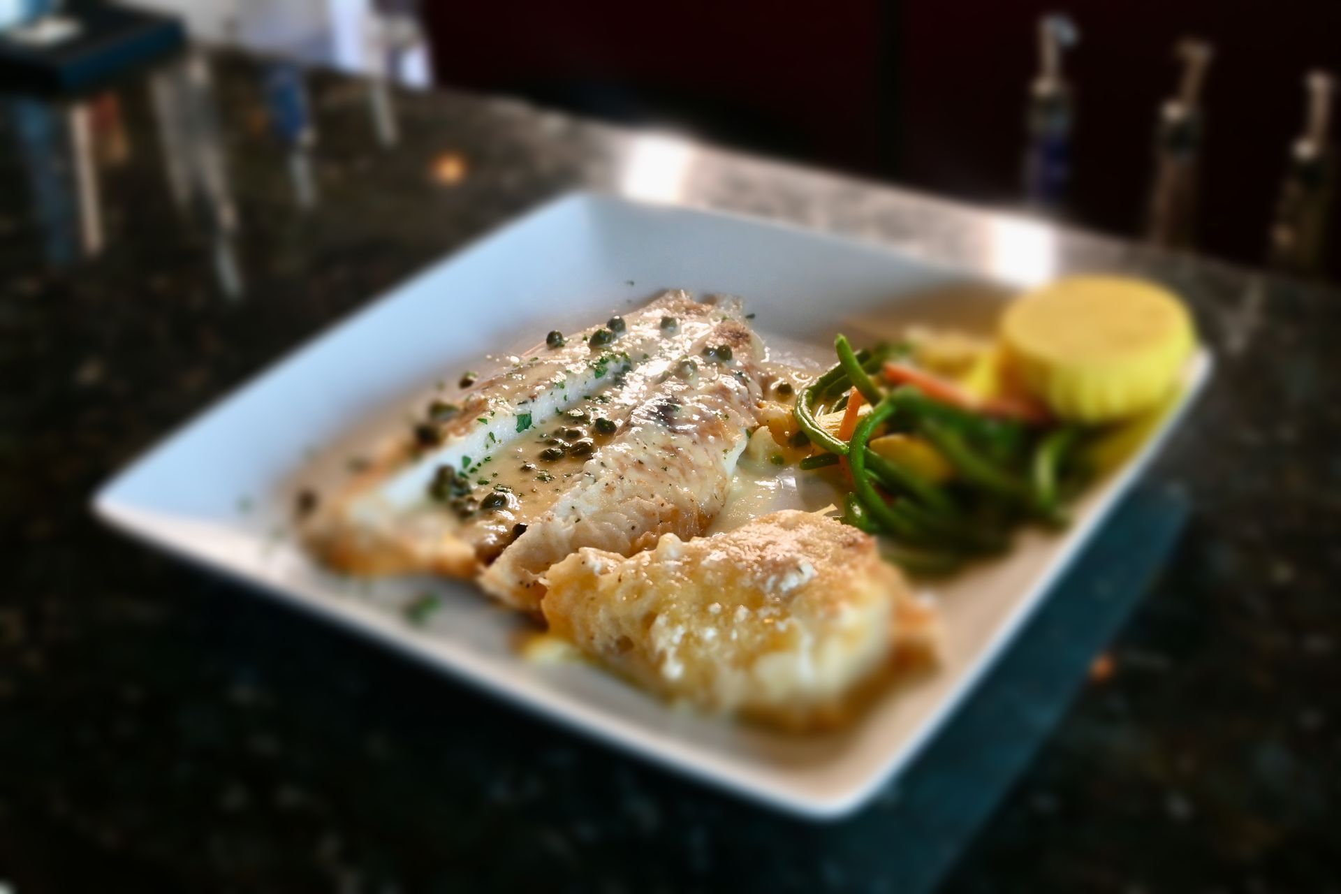 Baked seafood gratin served with vegetables and lemon, plated in a classic French bistro style.