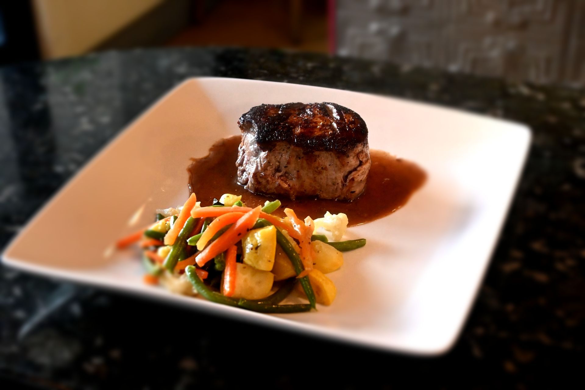 Seared beef entrée plated with seasonal vegetables and a rich sauce, showcasing Chez Pierre’s refined culinary style.