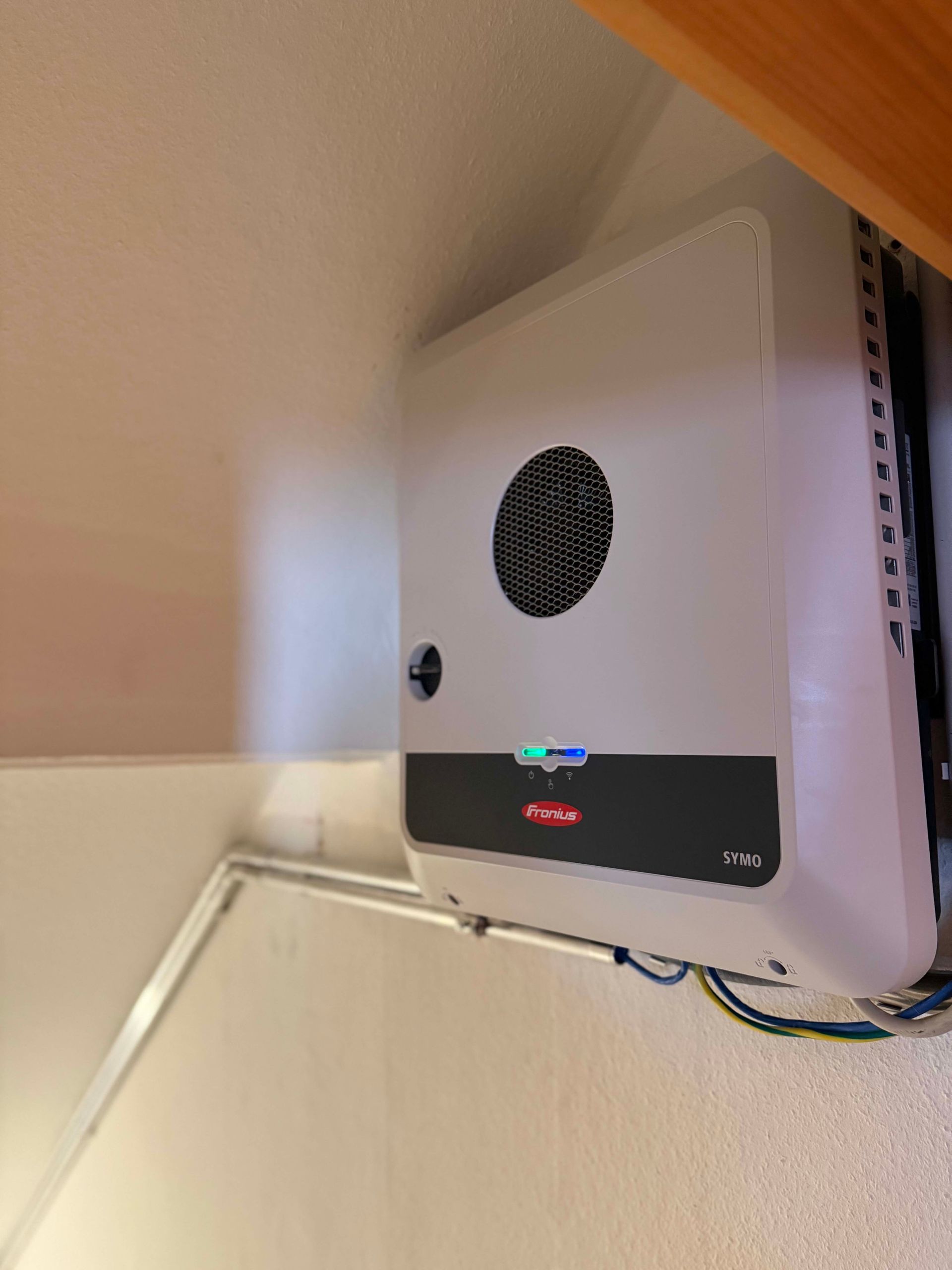 Weißes, an der Wand montiertes Gerät mit runder Lüftungsöffnung
