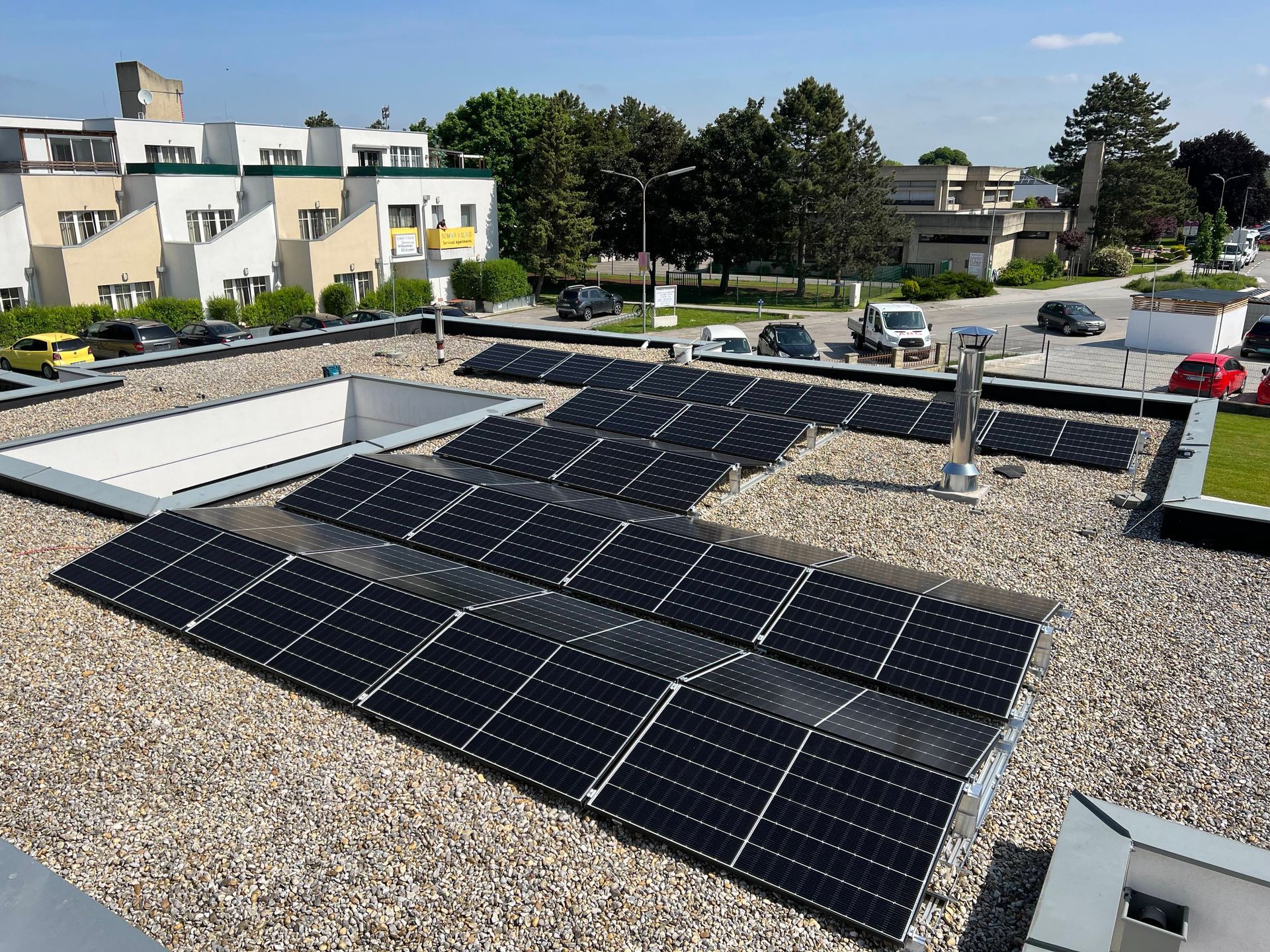 Solarpaneele auf einem Kiesdach in einem Vorstadtviertel unter klarem Himmel