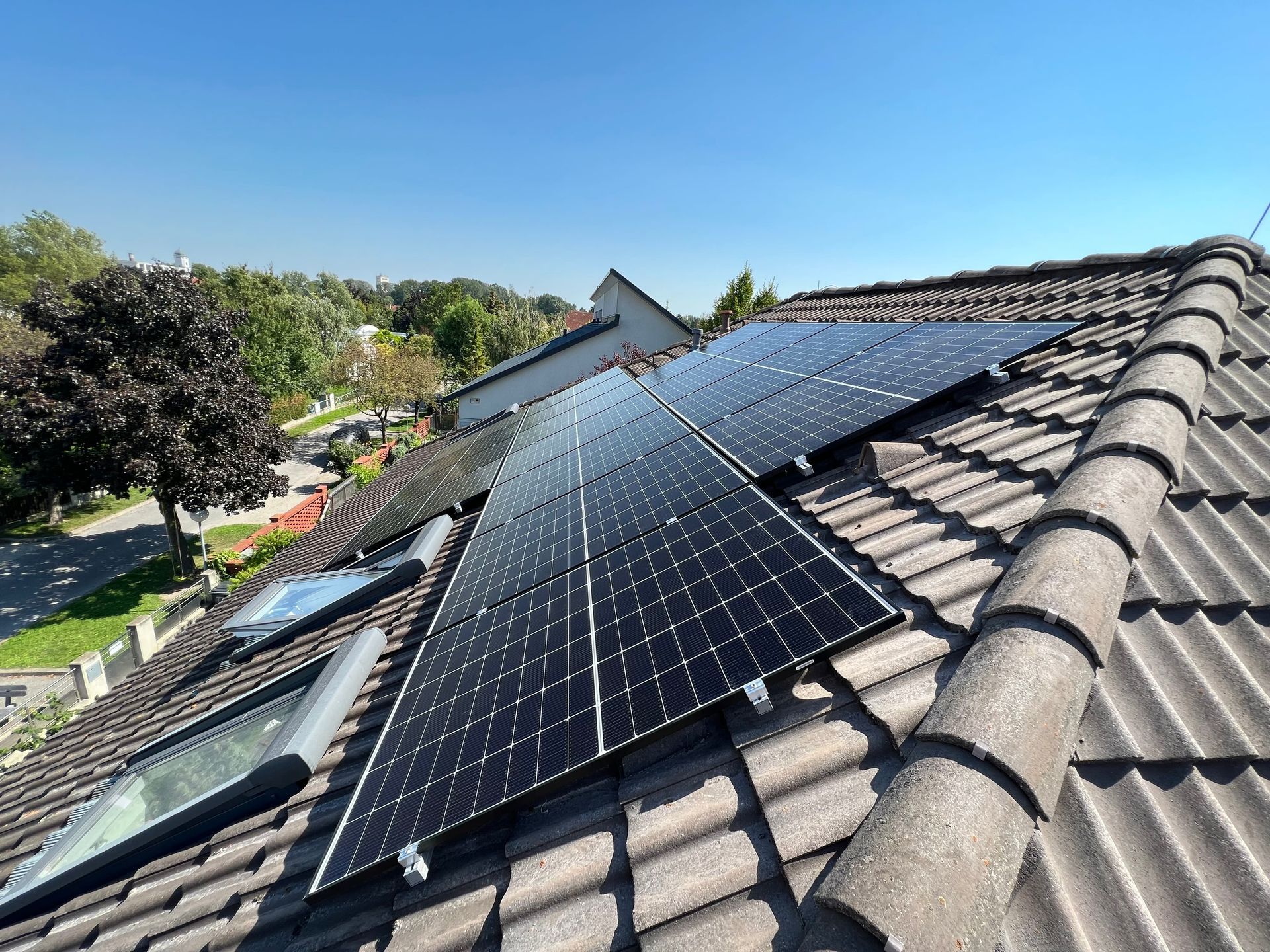 Solarpaneele, montiert auf einem Ziegeldach unter einem klaren blauen Himmel