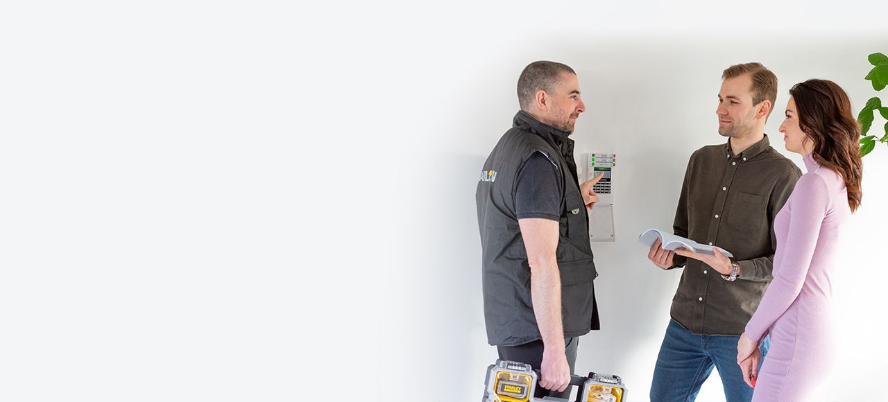 Drei Kollegen unterhalten sich in einem hellen Büro, einer von ihnen hält ein Tablet in der Hand.