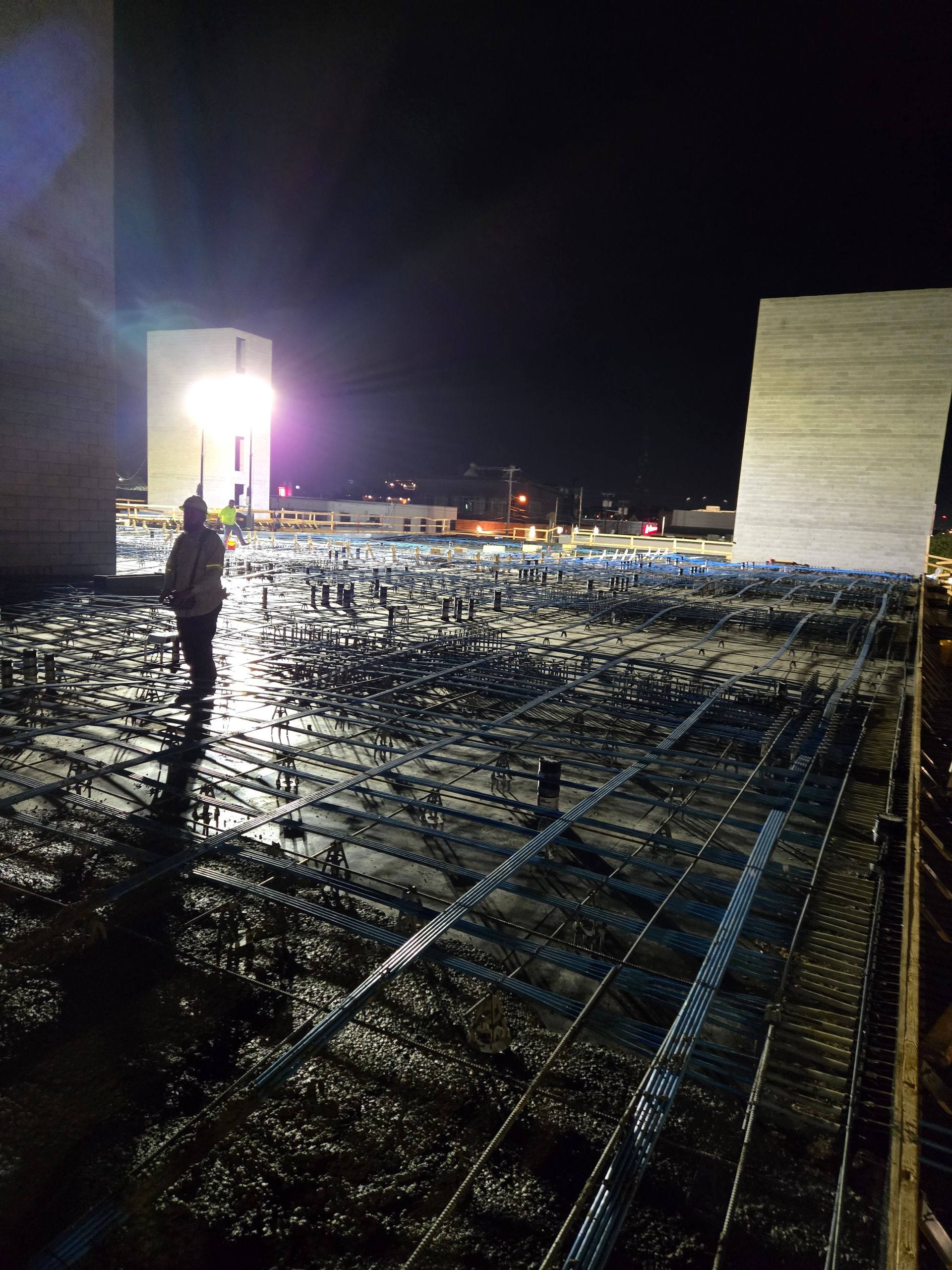A person is standing on a concrete floor at night.