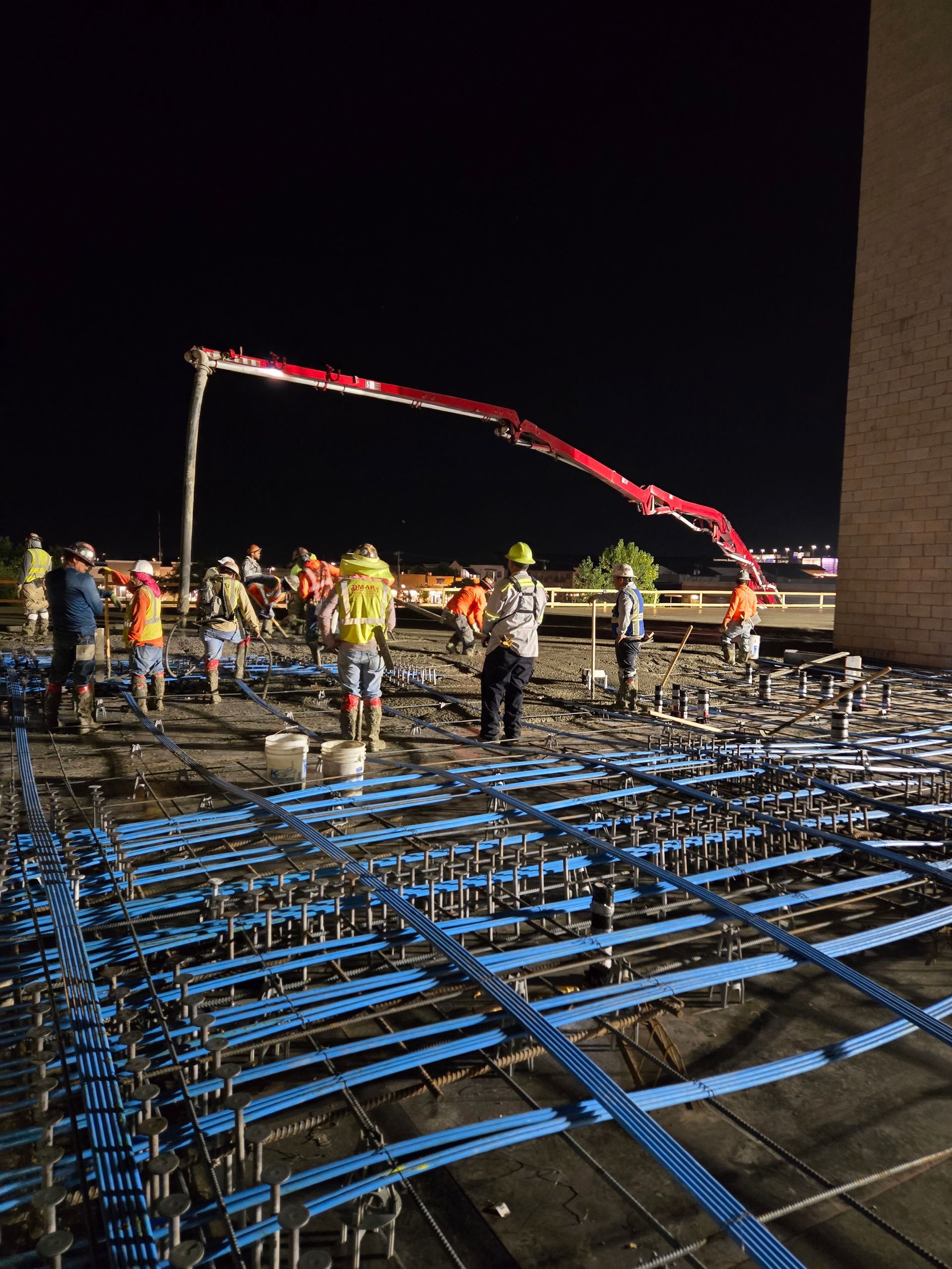 A group of construction workers are working on a roof at night.