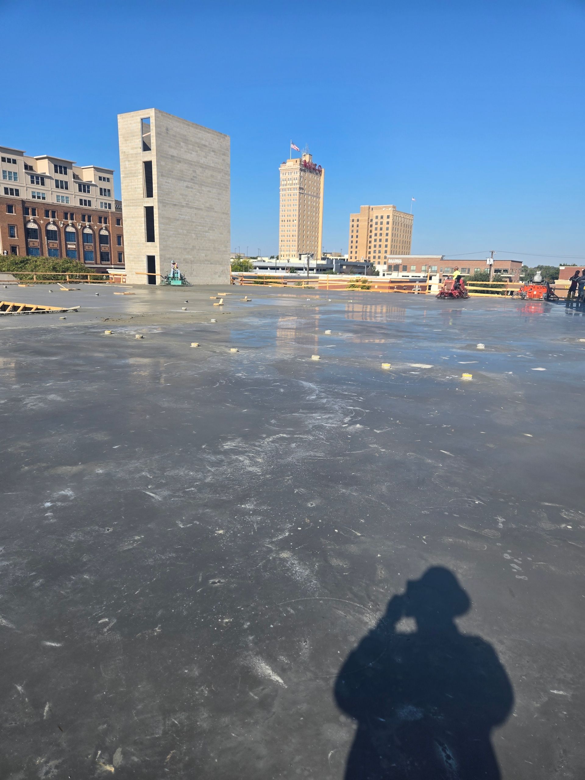 A shadow of a person is cast on a concrete surface