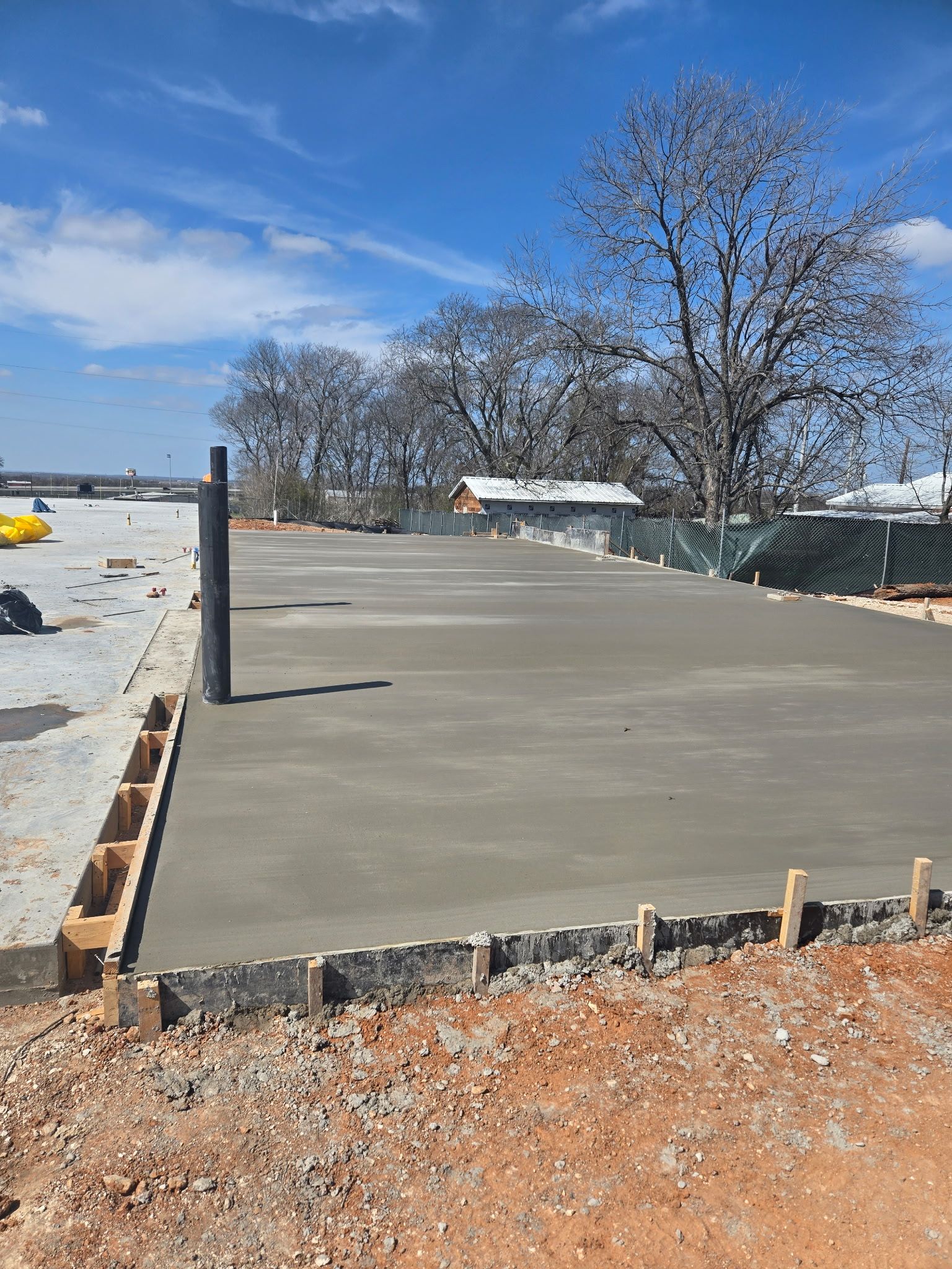 Concrete slab foundation under construction with wooden forms and a blue sky overhead