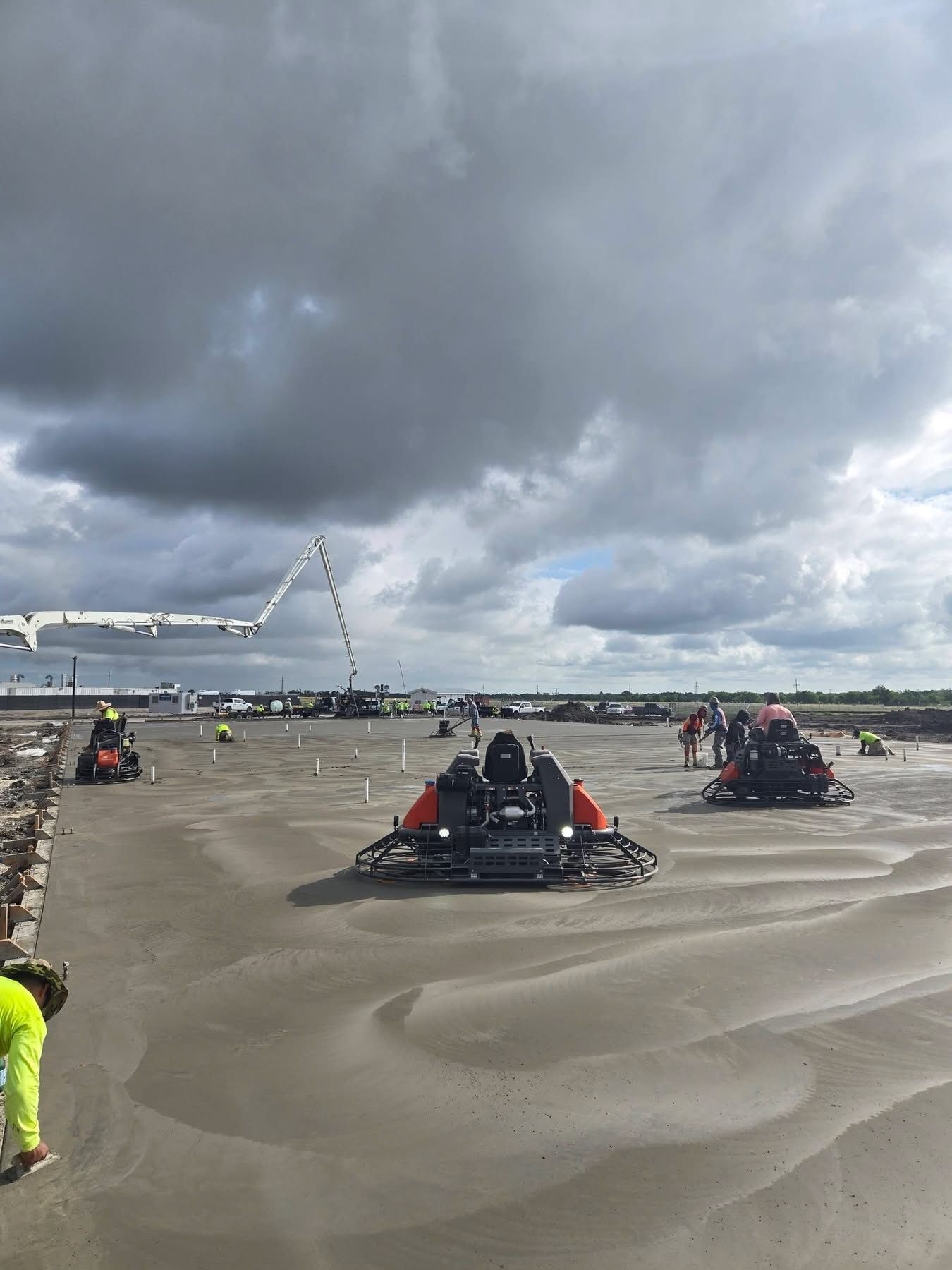 Go-karts racing on a wet track under cloudy skies, with spectators along the sides.