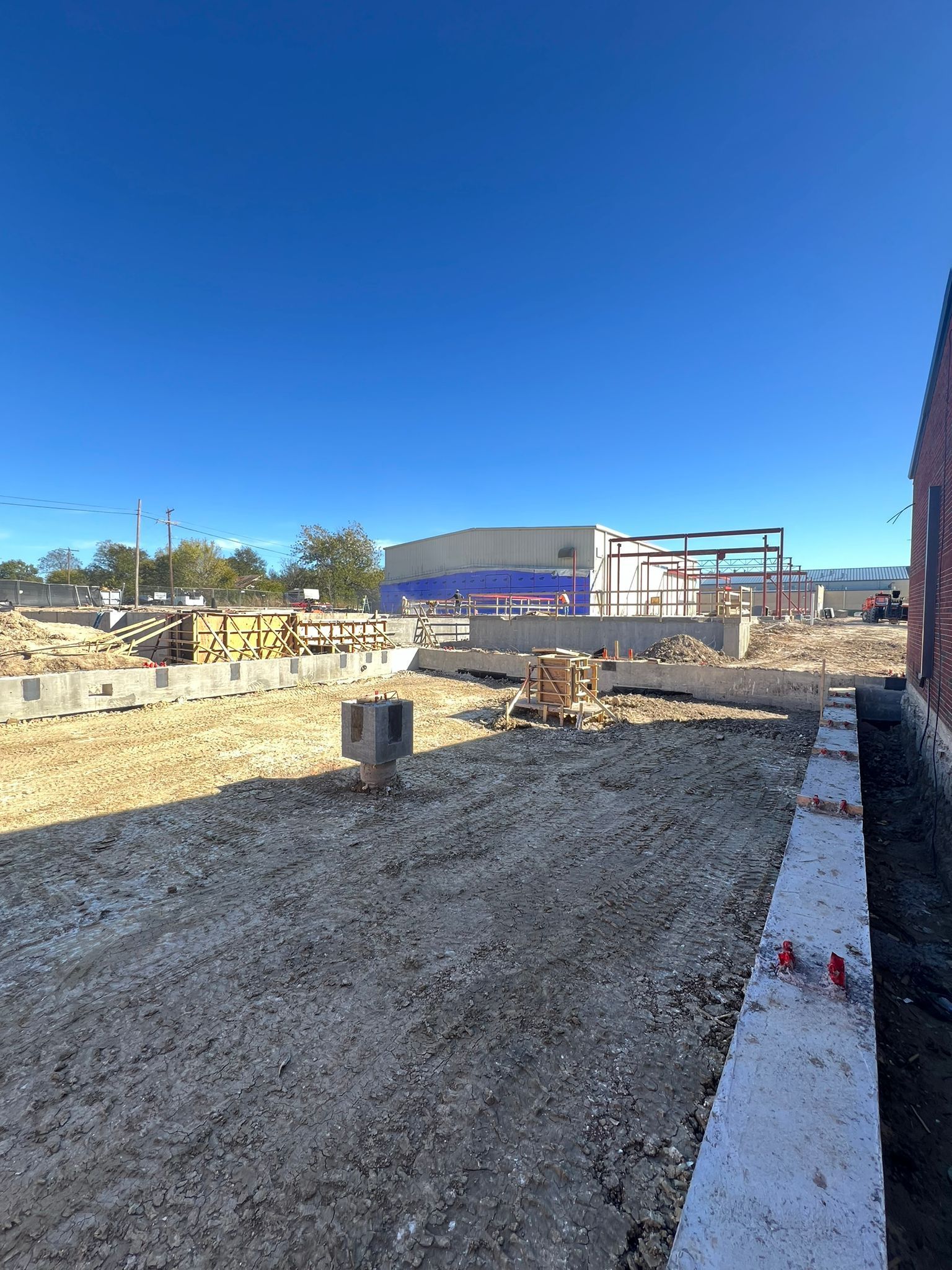A construction site with a large building in the background.