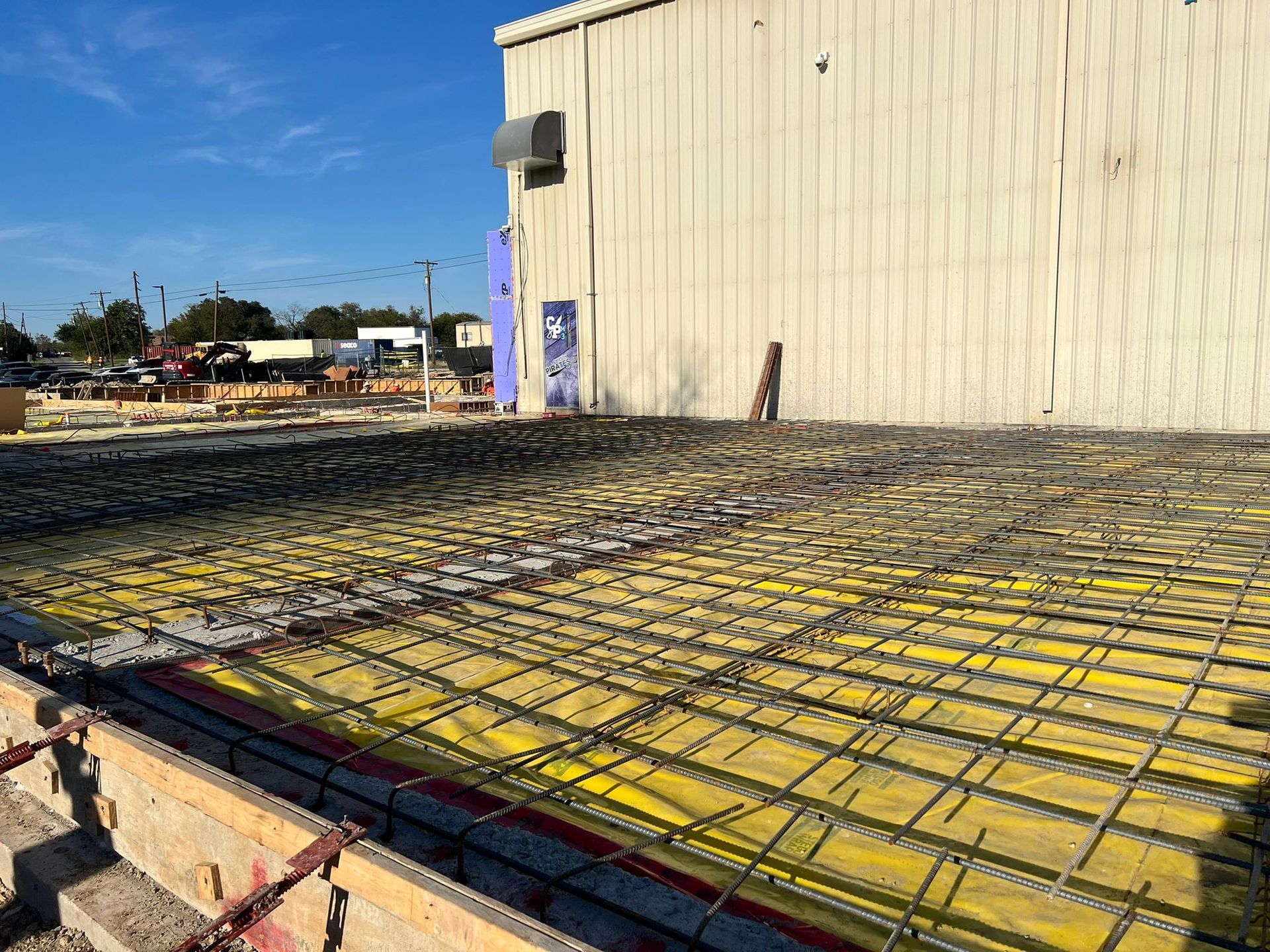 A concrete floor is being built in front of a building.