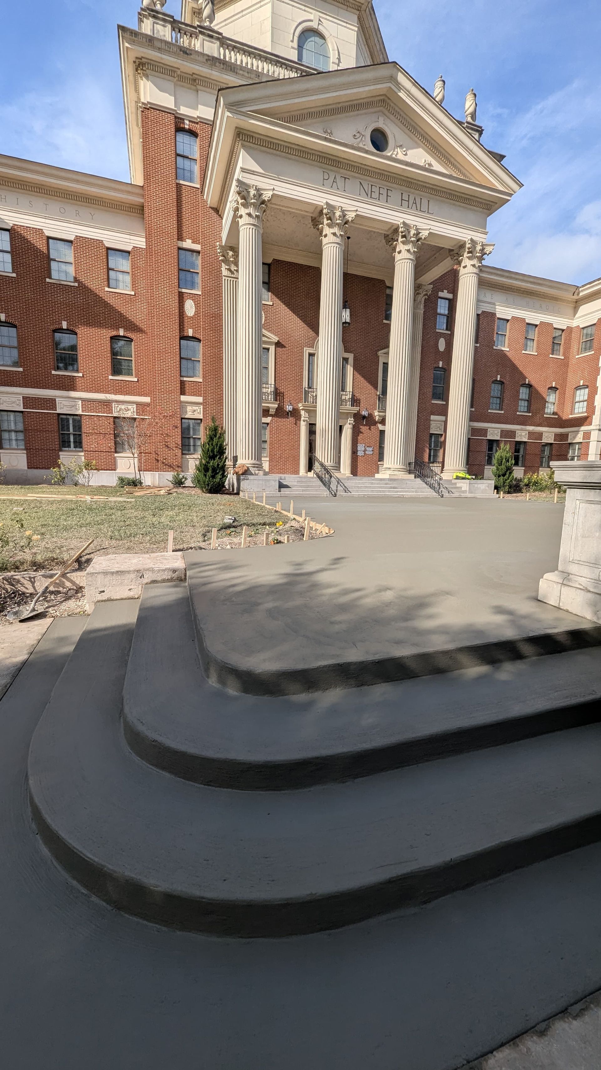 A large brick building with a concrete walkway in front of it.