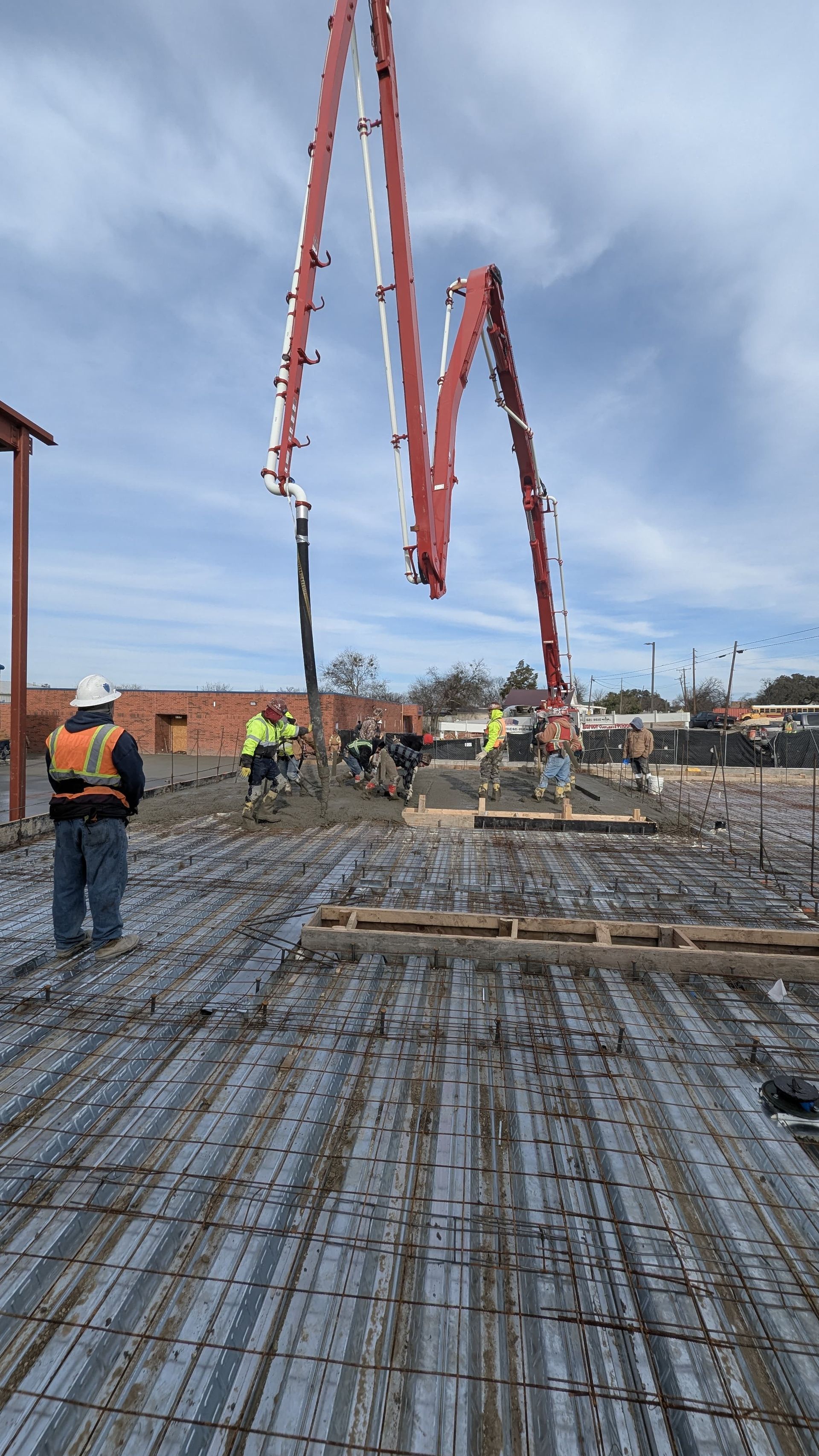 A group of construction workers are working on a concrete floor.