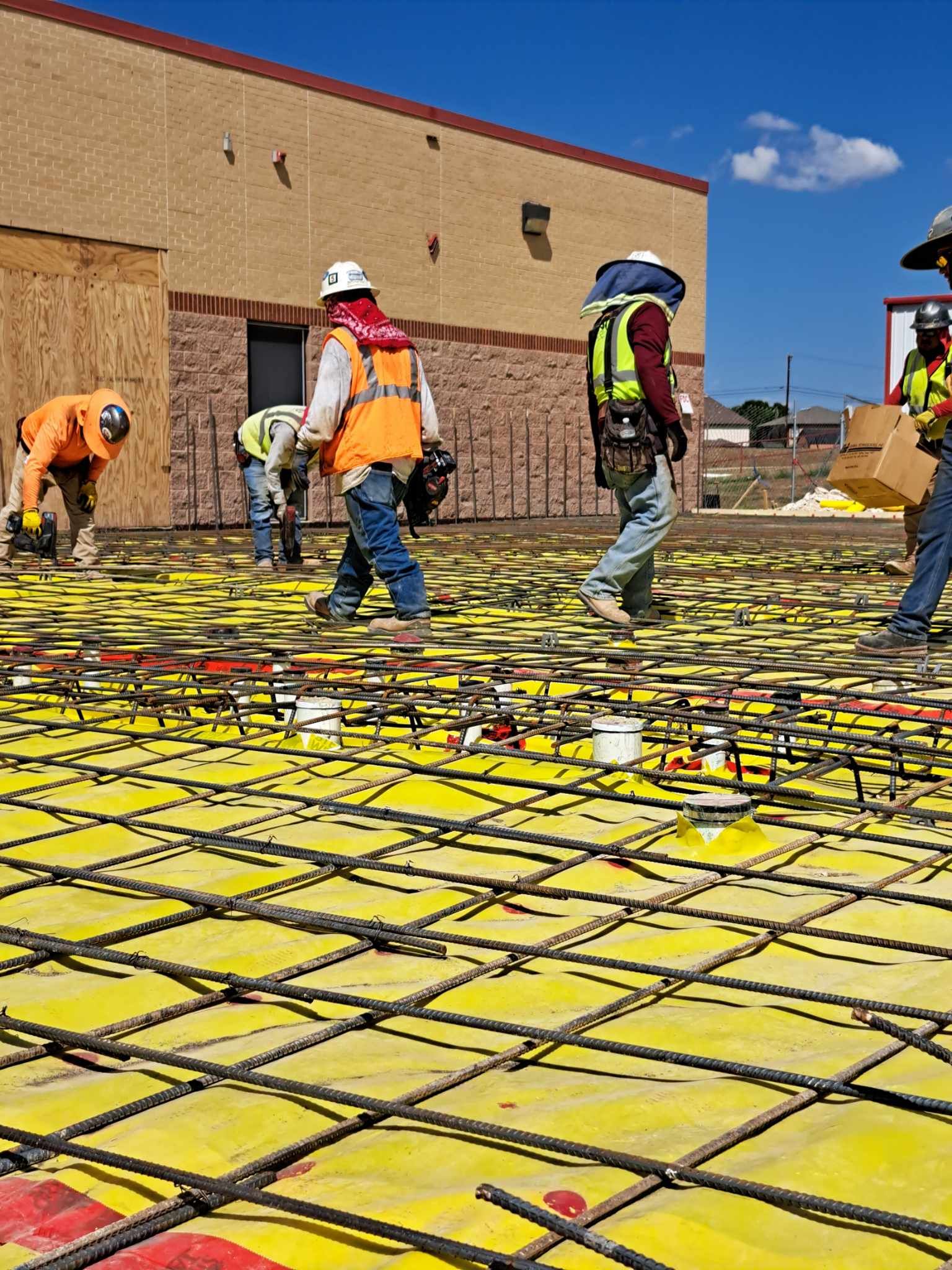 A group of construction workers are working on a concrete floor.