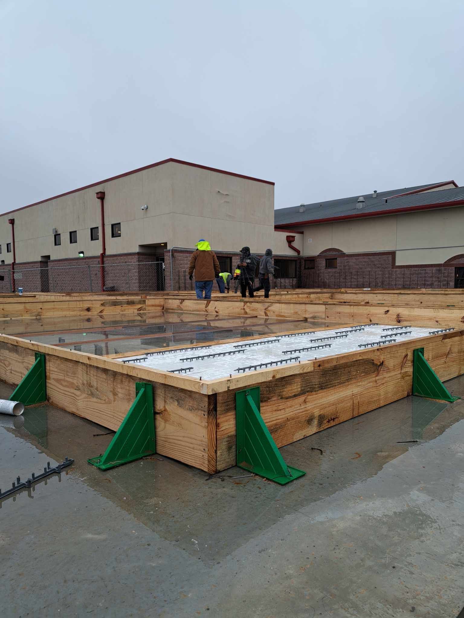 A group of construction workers are standing in front of a building under construction.