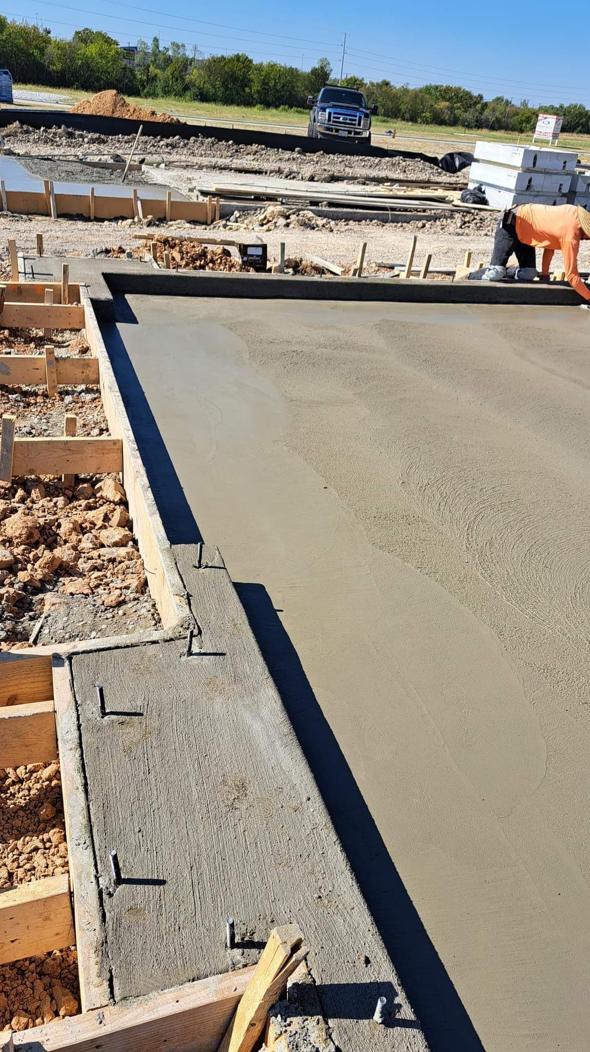 A man is pouring concrete on a construction site.