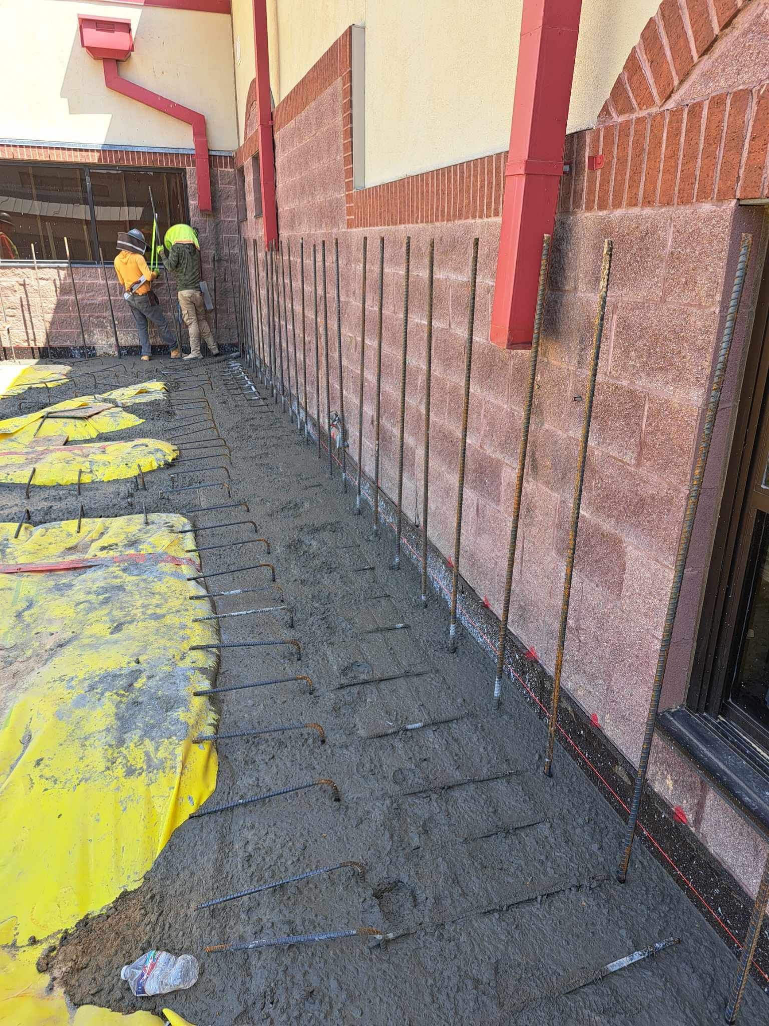 A group of construction workers are working on the side of a building.