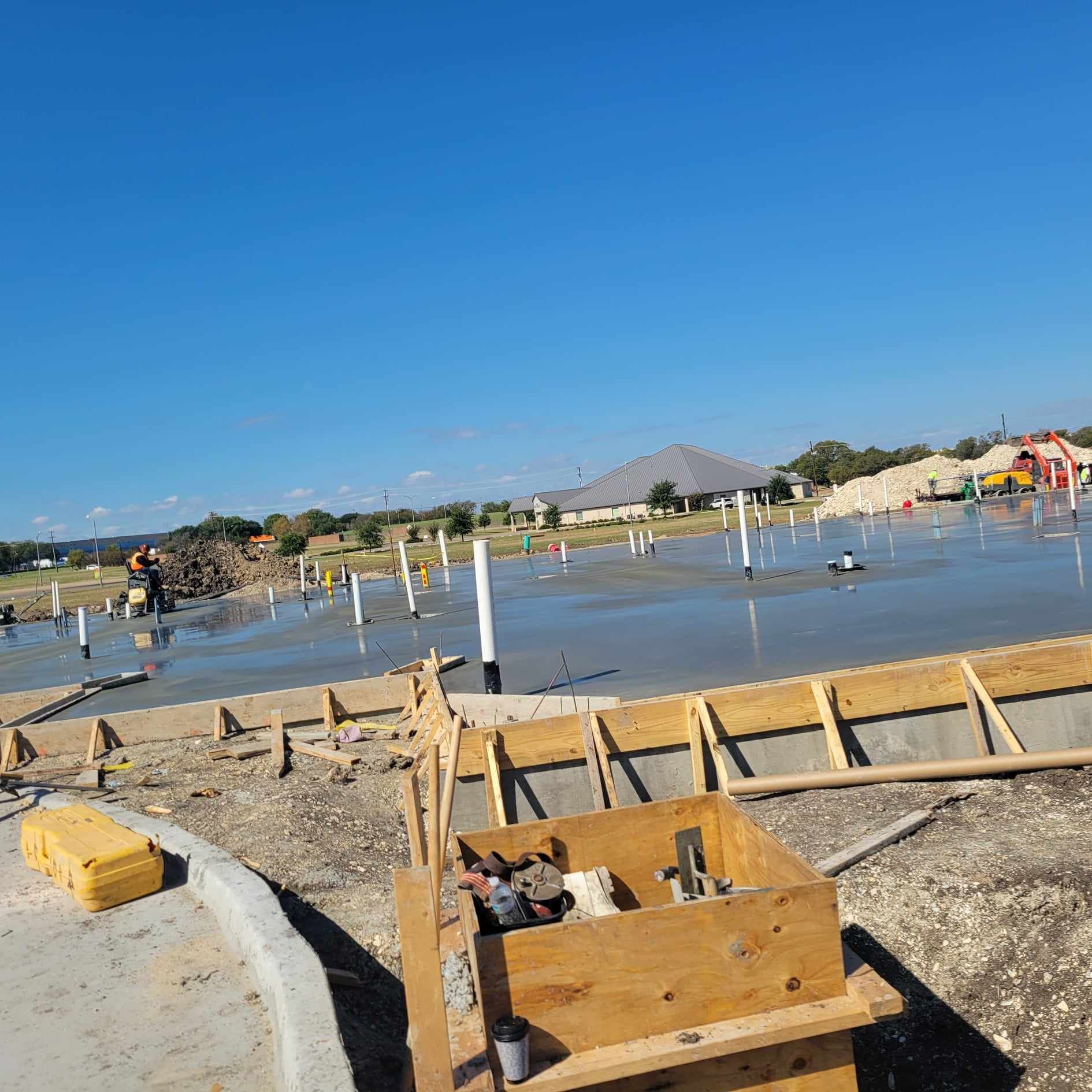 A construction site with a lot of concrete and wooden boxes.