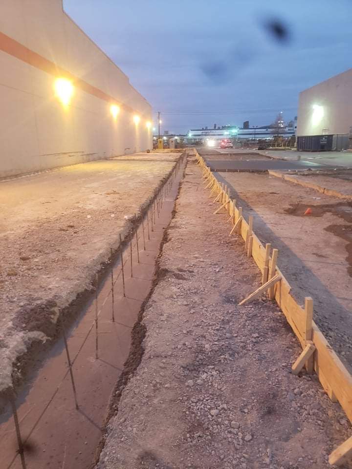 A concrete walkway is being built in front of a building.