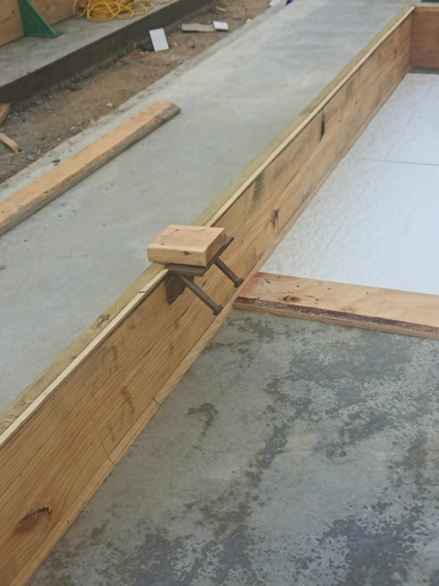 A wooden beam is sitting on top of a concrete surface