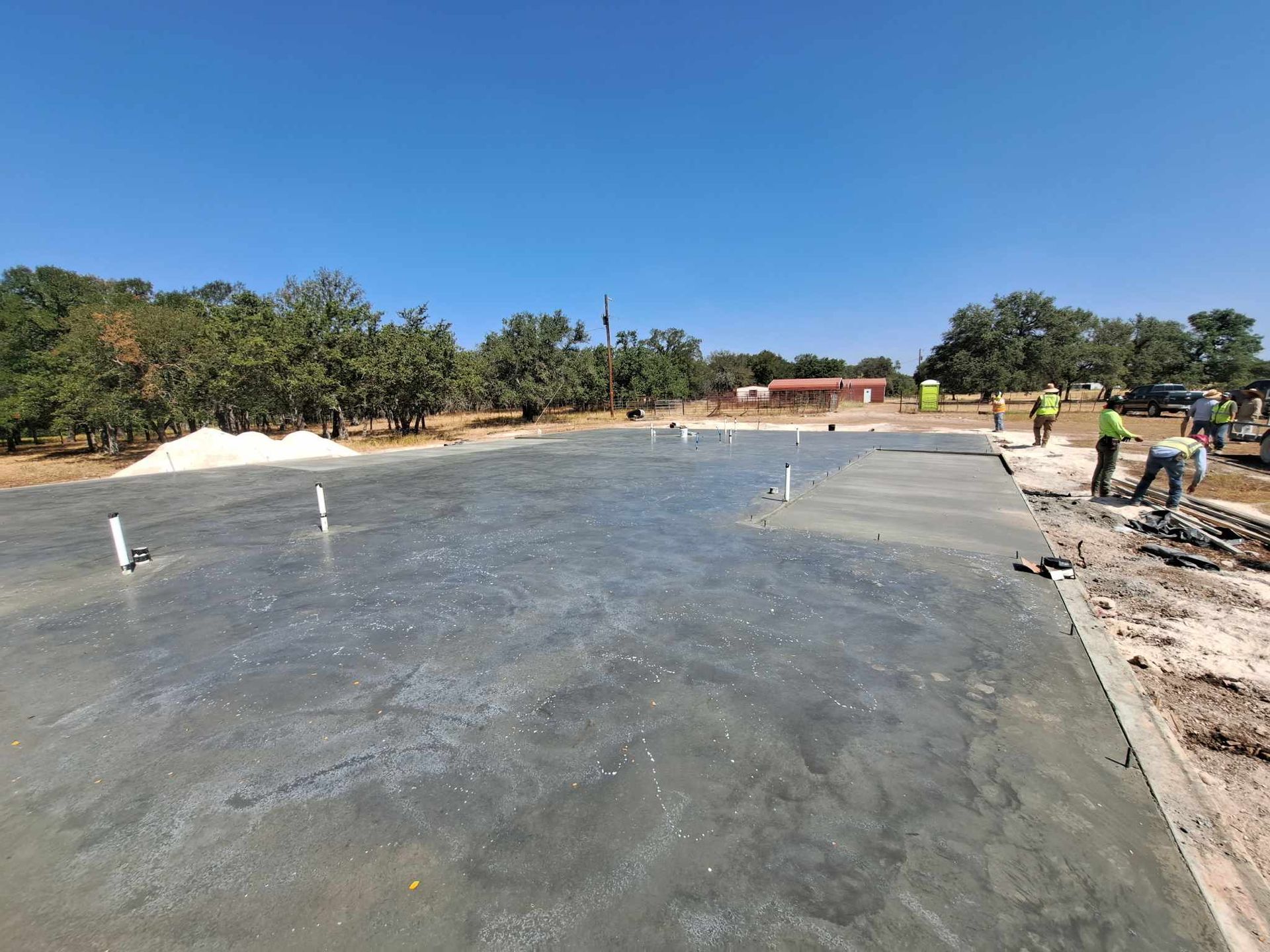 A group of construction workers are working on a concrete floor.