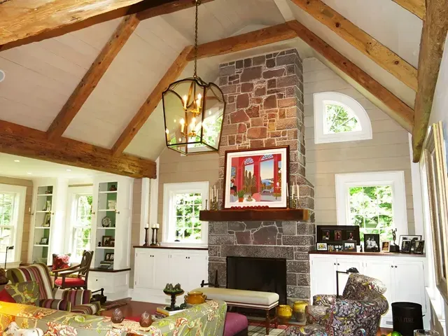 A living room with a vaulted ceiling and a fireplace