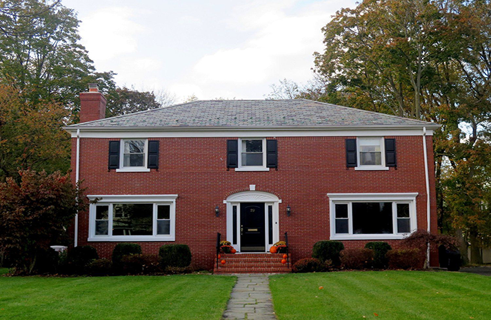 A large red brick house with white windows and black shutters