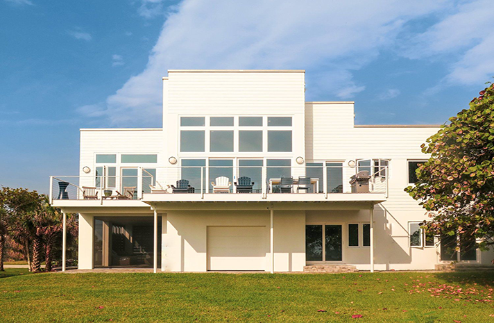 A large white house with a balcony and a lot of windows