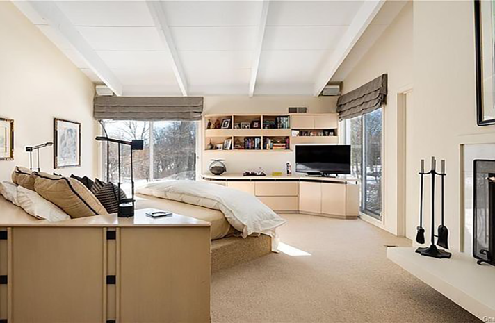 A bedroom with a large bed and a fireplace