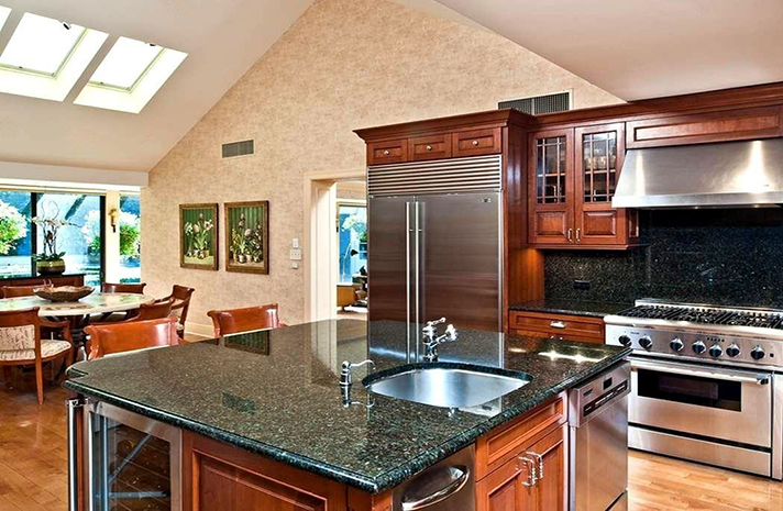 A kitchen with granite counter tops and stainless steel appliances