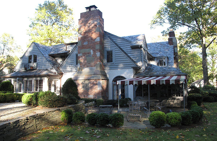 A large house with a red and white awning in front of it