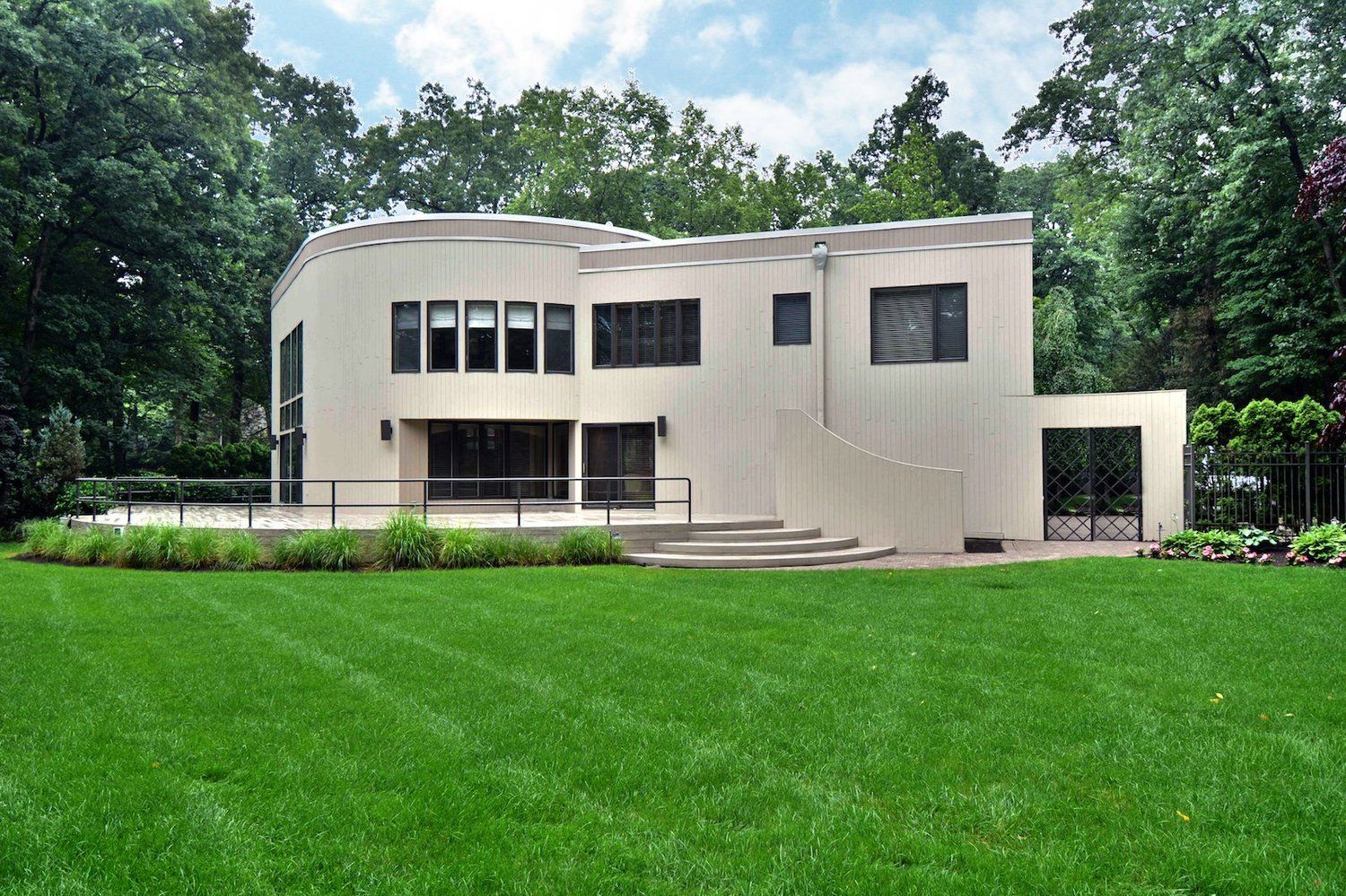 A large white house with a lush green lawn in front of it.