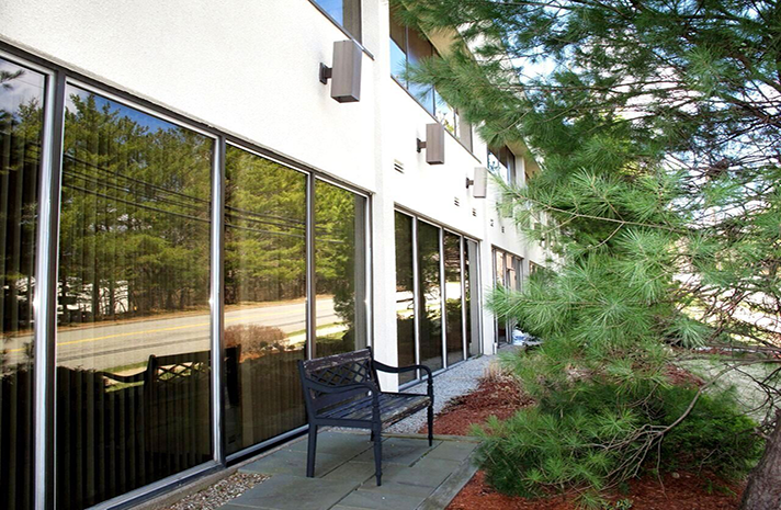 A building with a bench and trees in front of it