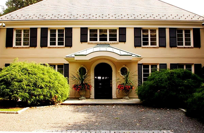 A large house with black shutters on the windows