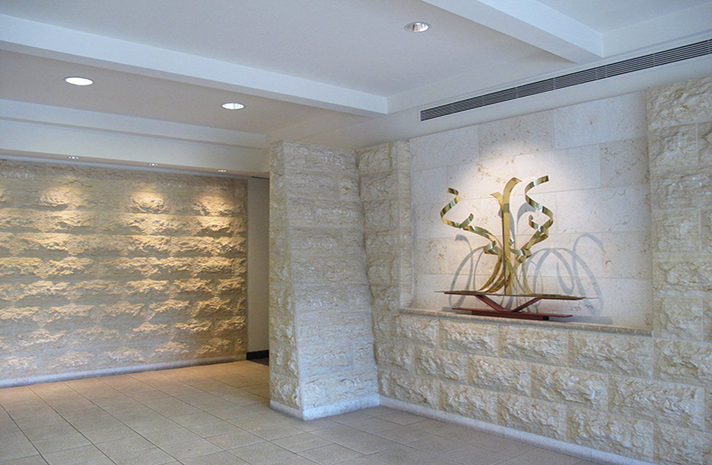 There is a sculpture on the wall in the middle of the room.