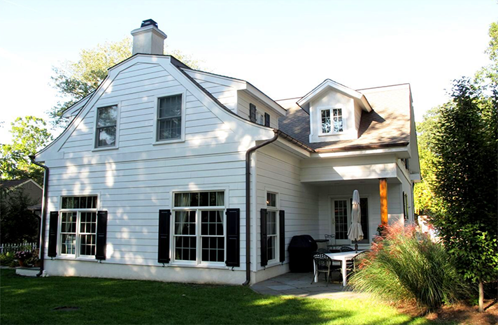 A white house with black shutters and a porch