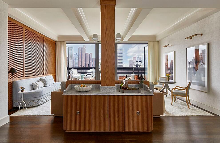 A living room with a couch , table , chairs and a large window.