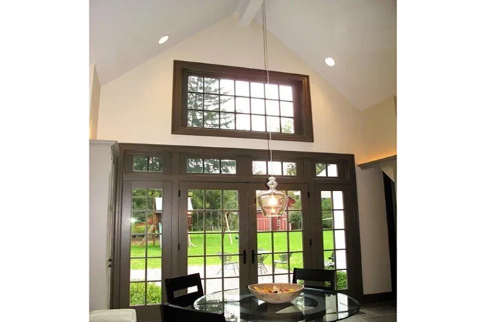 A dining room with a table and chairs and a large window