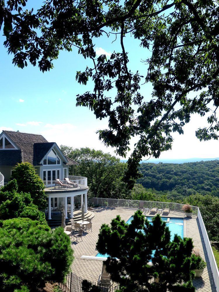 A large house with a swimming pool in front of it