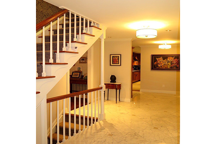 A hallway with stairs and a table in the middle
