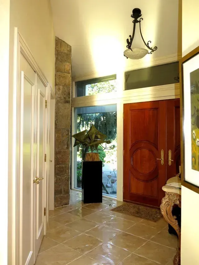A hallway with a red door and a picture on the wall