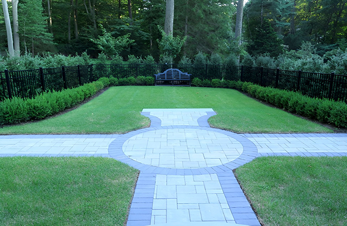 A lush green lawn with a bench in the middle