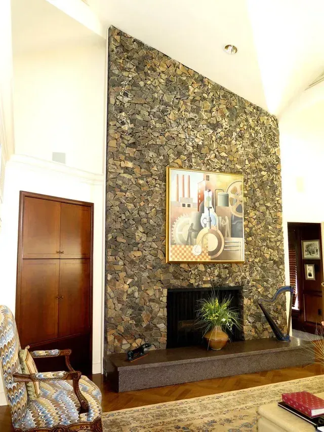 A living room with a fireplace and a painting on the wall
