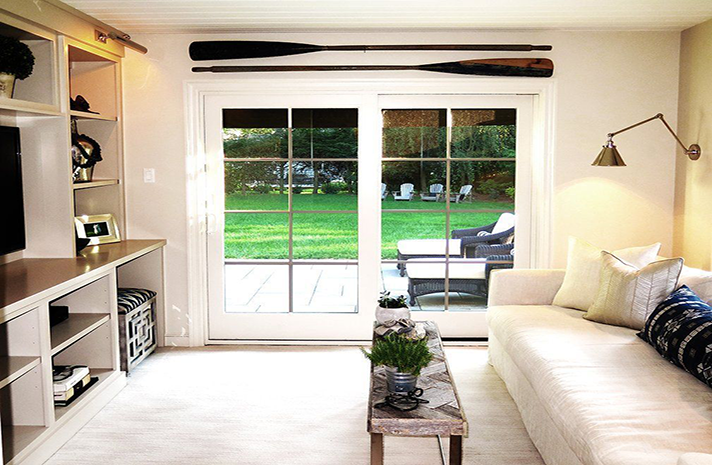 A living room with a couch and oars on the wall