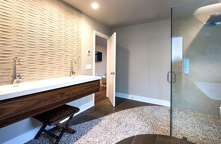 A bathroom with a walk in shower and a sink.