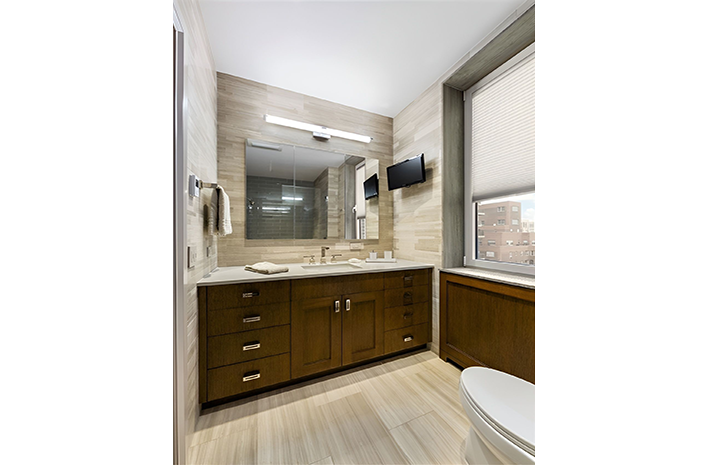 A bathroom with two sinks , a toilet , and a large mirror.