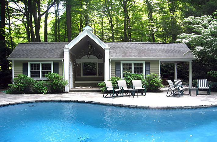 A house with a swimming pool in front of it