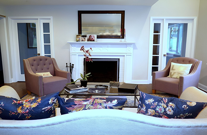 A living room with a couch , chairs , coffee table and fireplace.