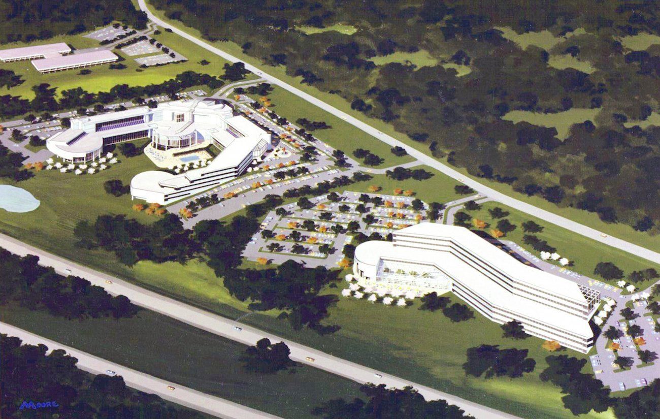 An aerial view of a large white building in the middle of a field
