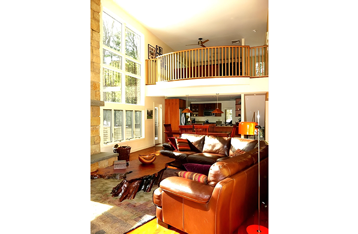 A living room with a couch and chairs and a balcony