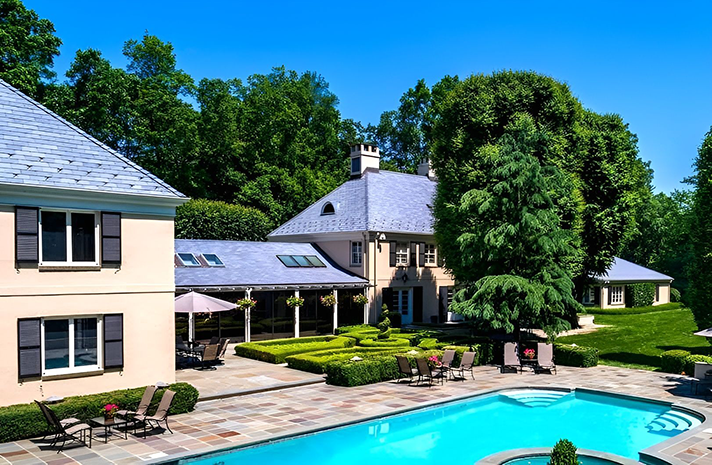 A large house with a swimming pool in front of it