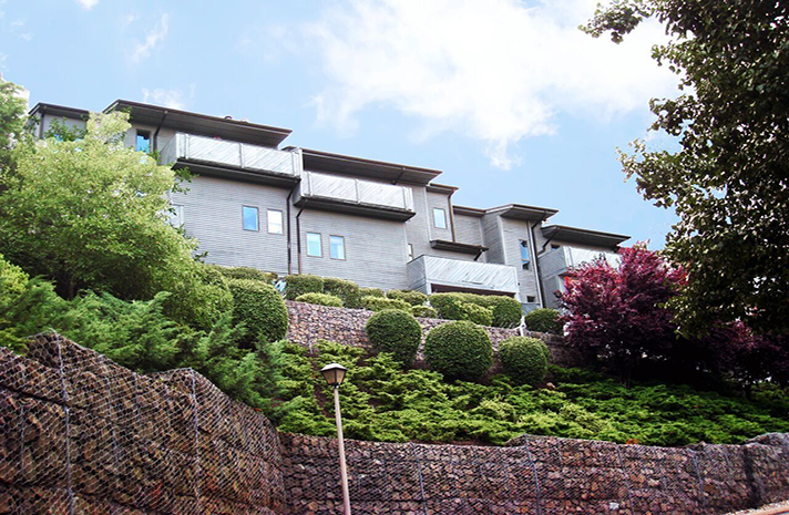 A large building on a hill surrounded by trees and bushes